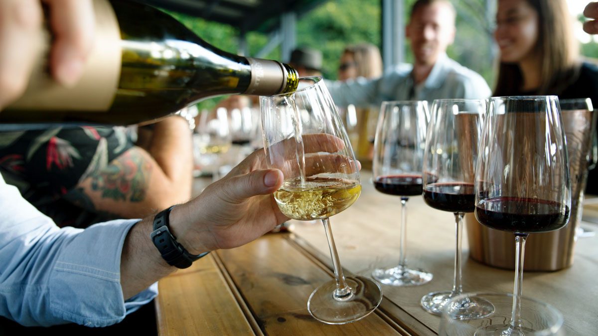 Touchpoint: Bei einer Weinprobe wird ein Glas mit Wein eingeschenkt.