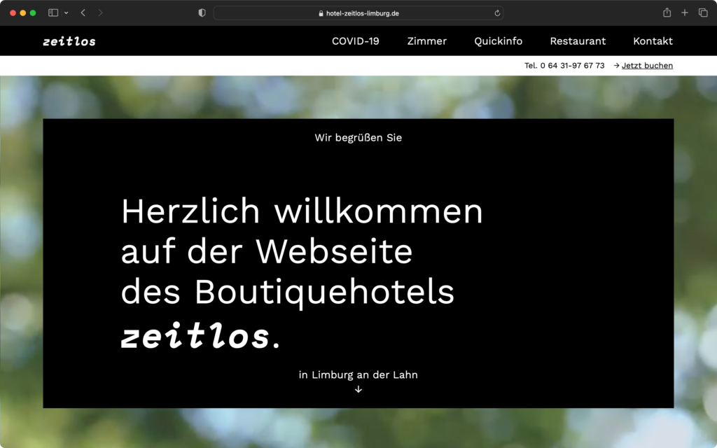 Startseite der Webseite des Boutiquehotels zeitlos in Limburg an der Lahn mit Menüleiste und Willkommensgruß auf schwarzem Hintergrund.
