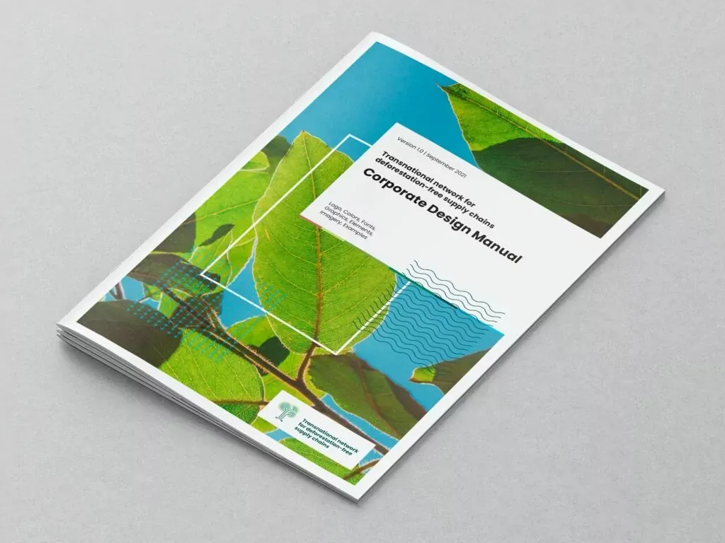 Auf dem Bild ist ein aufgeschlagenes Corporate Design Manual mit einem grünen Blätter-Motiv auf dem Cover und Text in englischer Sprache zu sehen.