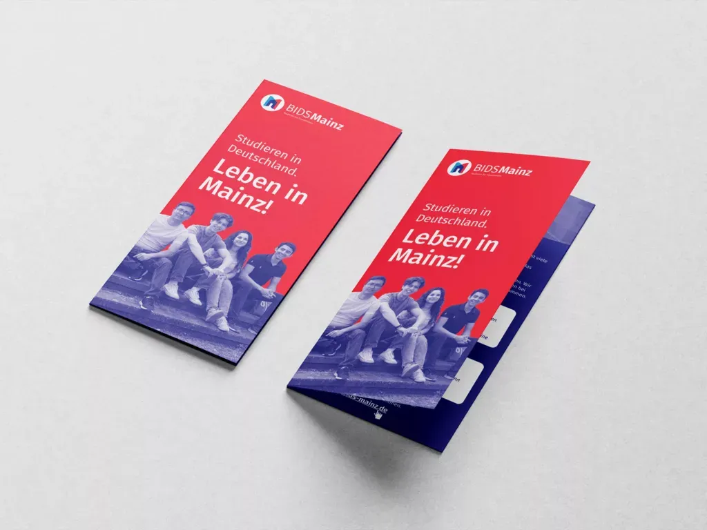 Zwei rote Flyer mit der Aufschrift Studieren in Deutschland Leben in Mainz und einem Bild von vier jungen Menschen, die auf einer Treppe sitzen.
