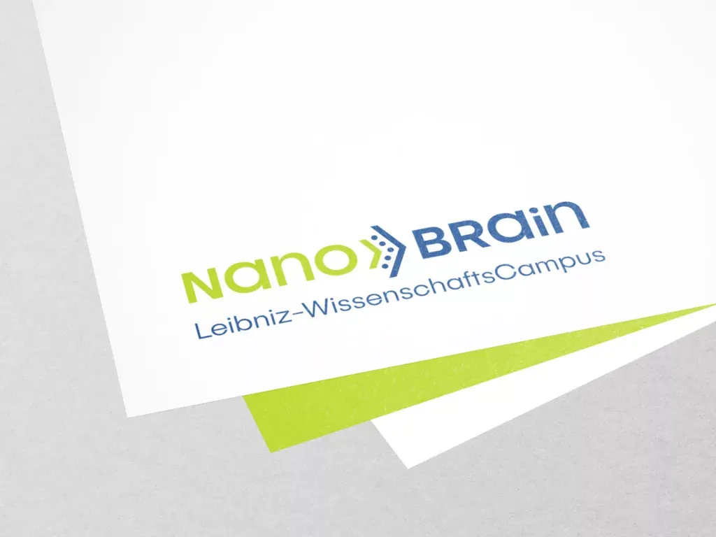 Logo mit dem Schriftzug Nano Brain Leibniz-WissenschaftsCampus auf weißem Papier mit grünem und grauem Hintergrund.
